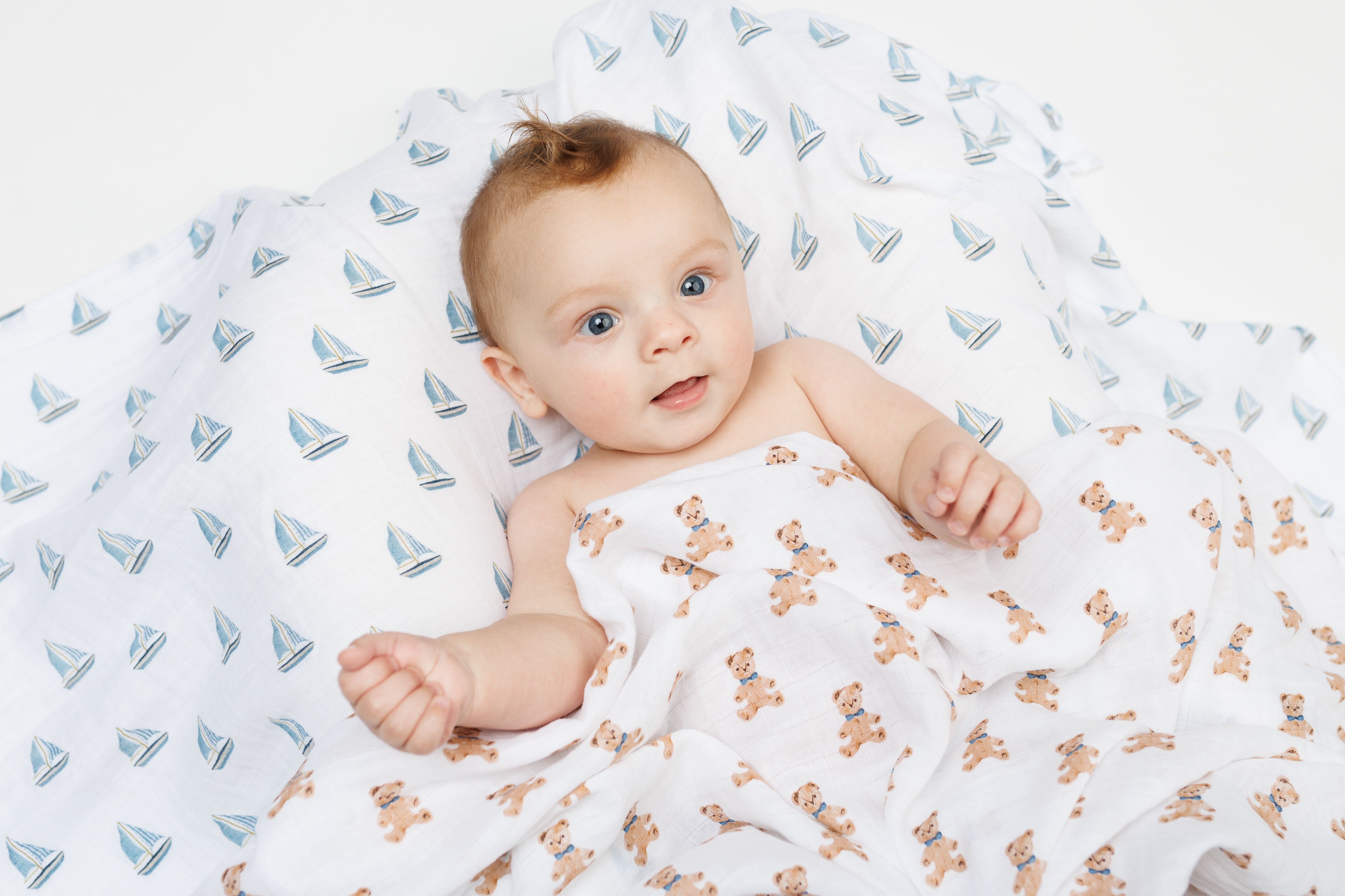Newborn baby wrapped in a Lulujo cotton muslin swaddle